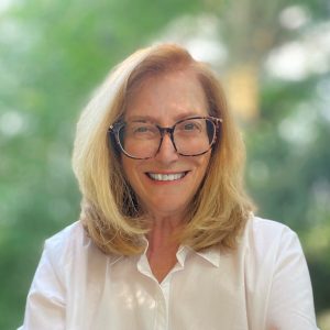 woman in a white shirt wearing glasses